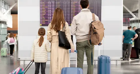 Un hombre, una mujes y un niño caminando en el aeropuerto
