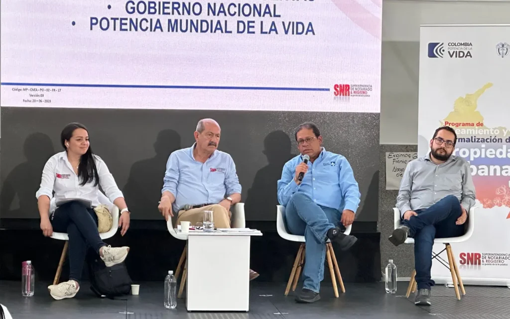 tres hombres y una mujer sentados dando una conferencia