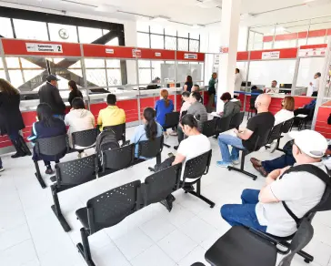 Varias personas sentadas en una oficina de registro